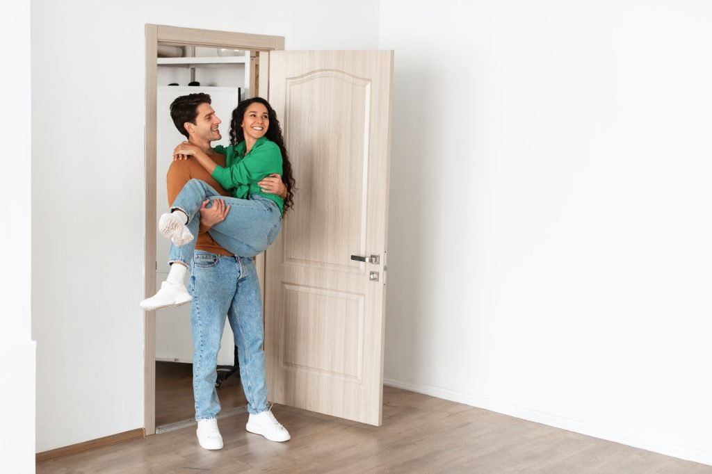 Happy young couple celebrating moving day in new flat